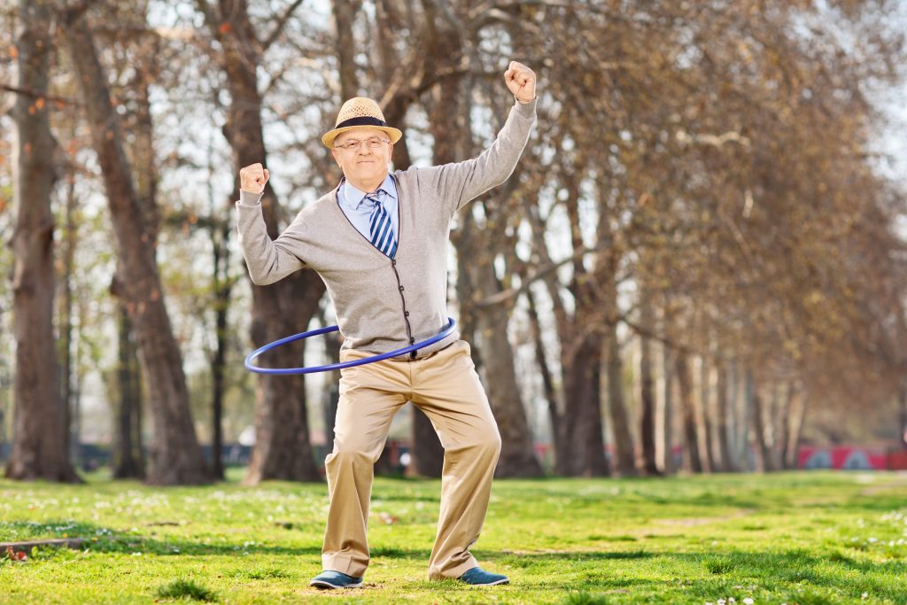 Older Man Using Hoolahoop in field